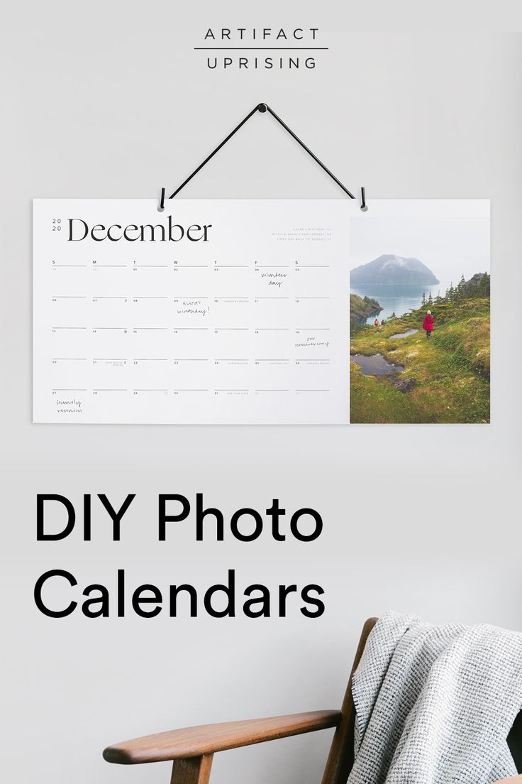 a calendar hanging on the wall next to a wooden chair