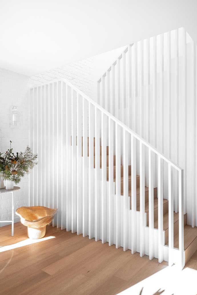 there is a white stair case next to a table