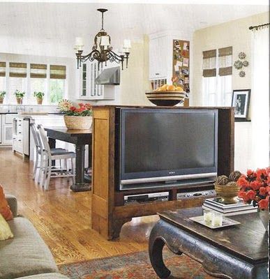 a living room filled with furniture and a flat screen tv on top of a wooden table