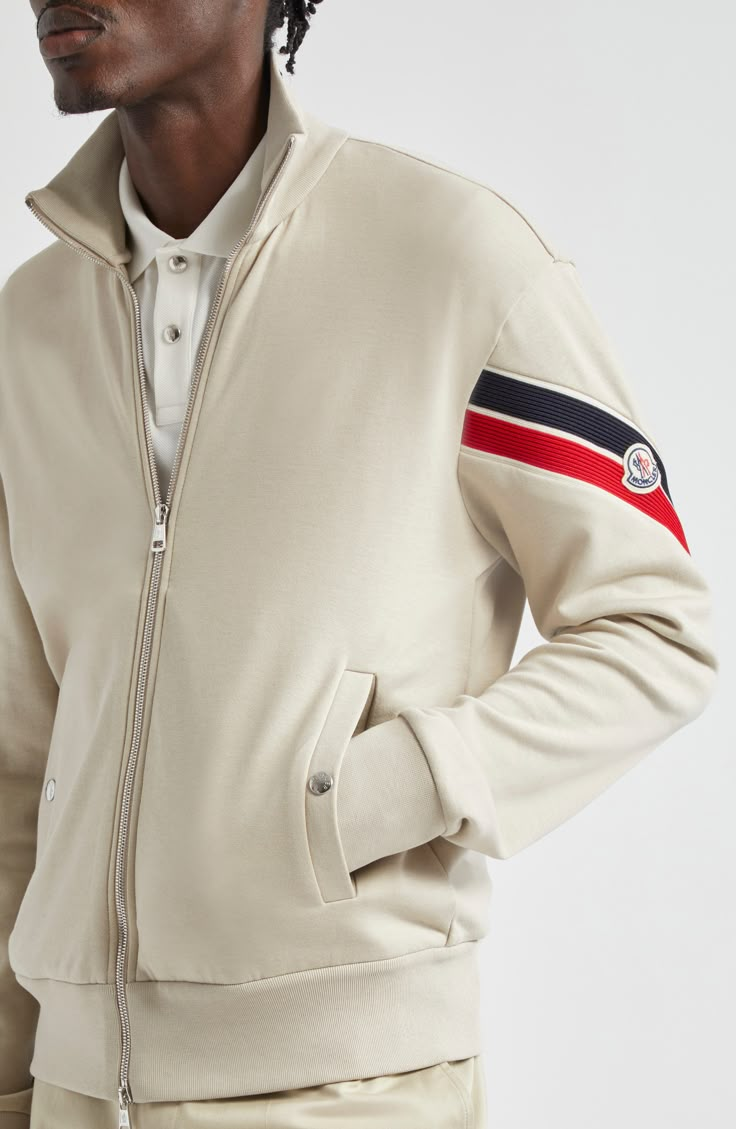 A ribbed armband rendered in the label's signature colors and detailed with a logo patch adds a heritage touch to a versatile jacket cut from cotton and nylon. Two-way front-zip closure Stand collar Front snap-welt pockets Ribbed cuffs and hem 87% cotton, 13% nylon Machine wash, dry flat Imported Designer Clothing Designer White Outerwear With Ribbed Cuffs, Designer Long Sleeve Outerwear With Logo Detail, Designer Long Sleeve Outerwear With Logo, Casual Outerwear With Signature Stripes For Streetwear, Casual Streetwear Outerwear With Signature Stripes, Luxury Cotton Outerwear For Streetwear, Classic Winter Outerwear With Logo Detail, Classic Winter Outerwear With Logo, Casual Track Jacket With Signature Stripes For Winter