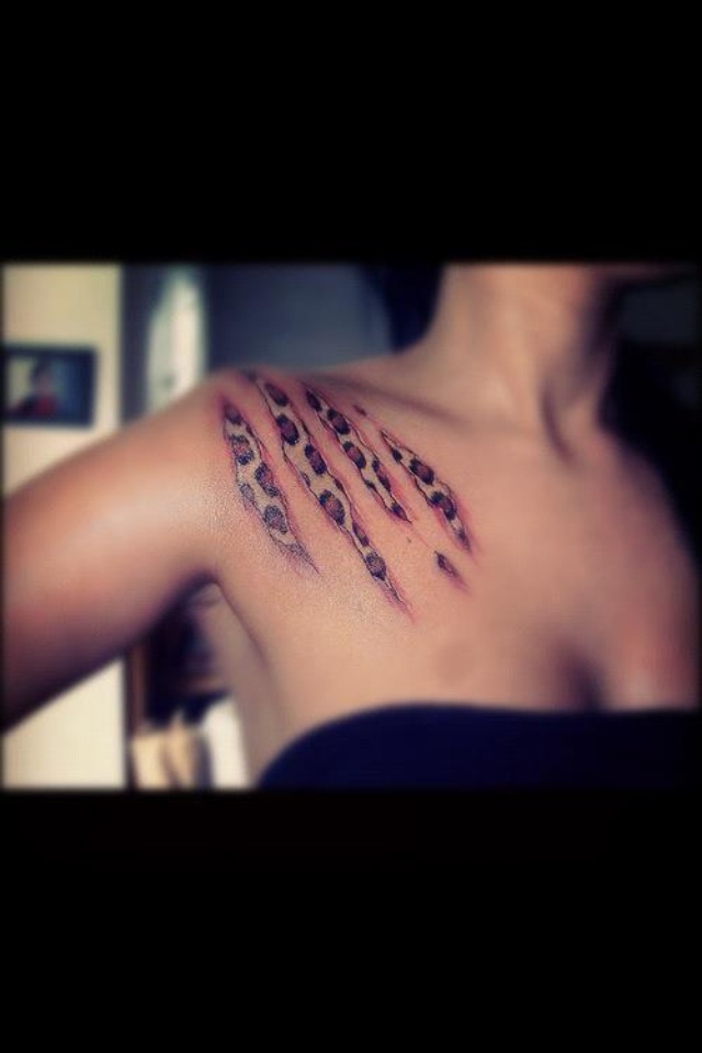 the back of a woman's shoulder with leopard print tattoos on it