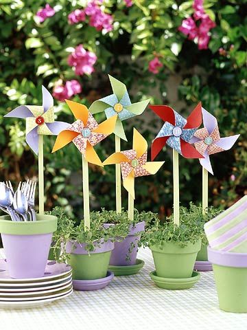 a table topped with potted plants and small pinwheels on top of each other