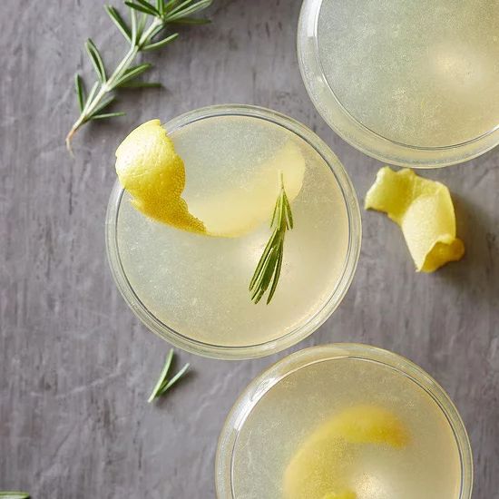 three glasses filled with lemonade and rosemary garnish