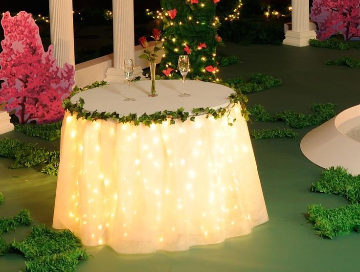 the table is covered with lights and greenery