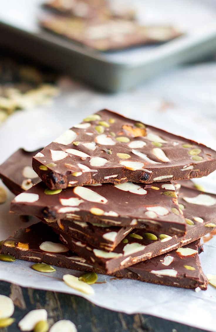 chocolate barkle with pistachio and almonds on a table next to a plate