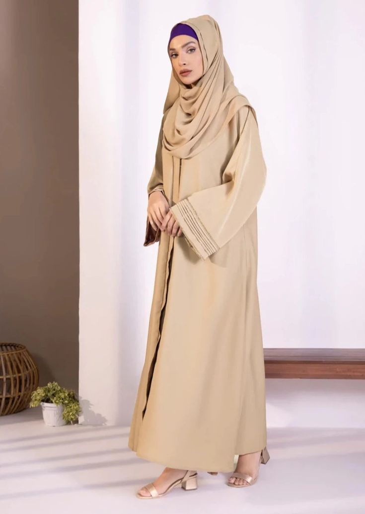 Abaya & hijab set for Women. Description : Abaya : Full length abaya in soft, drapey fabric. Button through front opening. V neckline. Full sleeves with diamanté and pleats detail. Material : Nidha Color: Beige Country : Made in Pakistan Elegant Solid Niqab For Eid, Elegant Niqab For Eid, Solid Long Niqab For Eid, Long Solid Niqab For Eid, Eid Wedding Solid Color Abaya, Solid Long Thobe For Eid, Long Thobe For Eid, Long Solid Color Hijab For Eid, Elegant Maxi Length Niqab For Eid