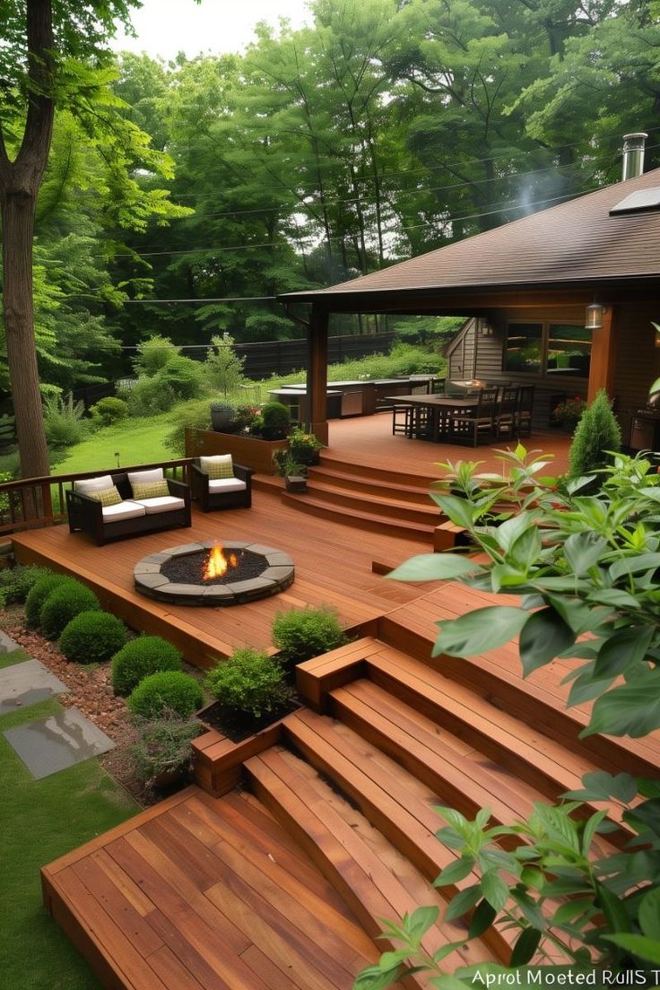 a wooden deck with steps leading up to a fire pit in the middle of it