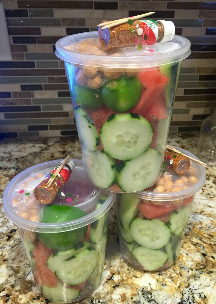 three plastic containers filled with cucumbers and other veggies on a counter