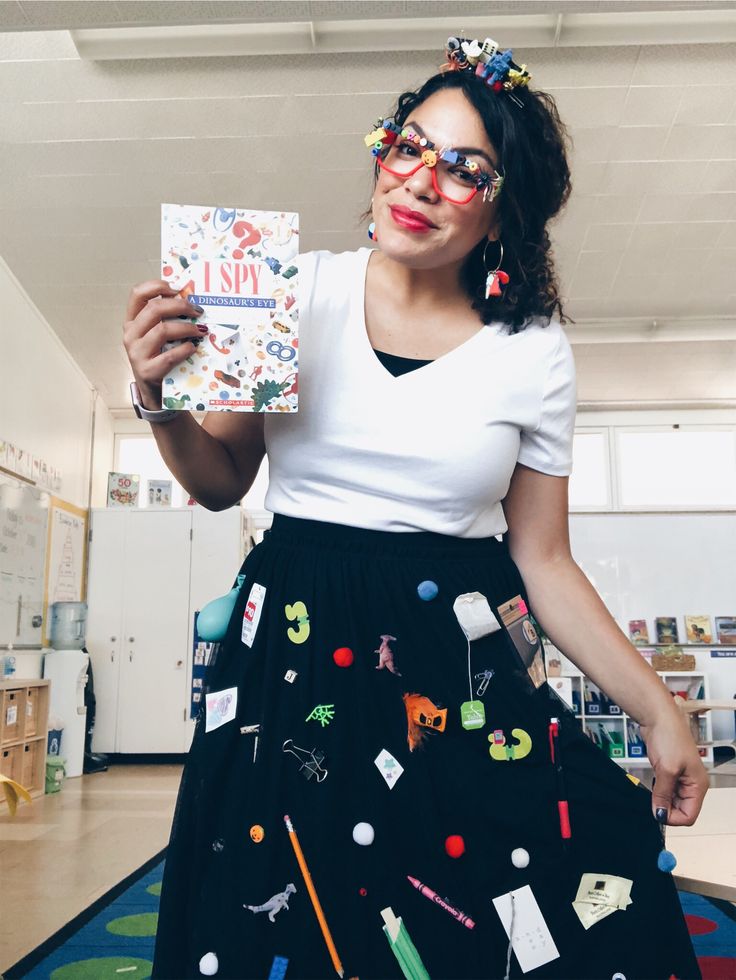 a woman wearing glasses holding up a card with the number one on it and various objects all over her face