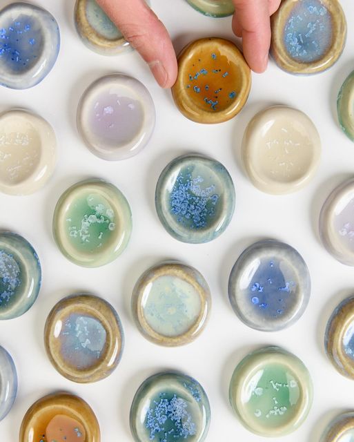 a person's hand reaching for an object in the middle of several glass circles