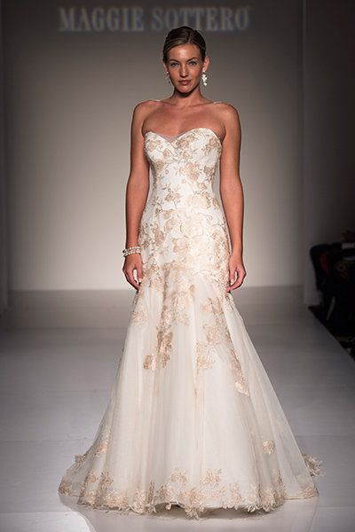 a white wedding dress with gold accents on the front and back, is displayed in an instagram