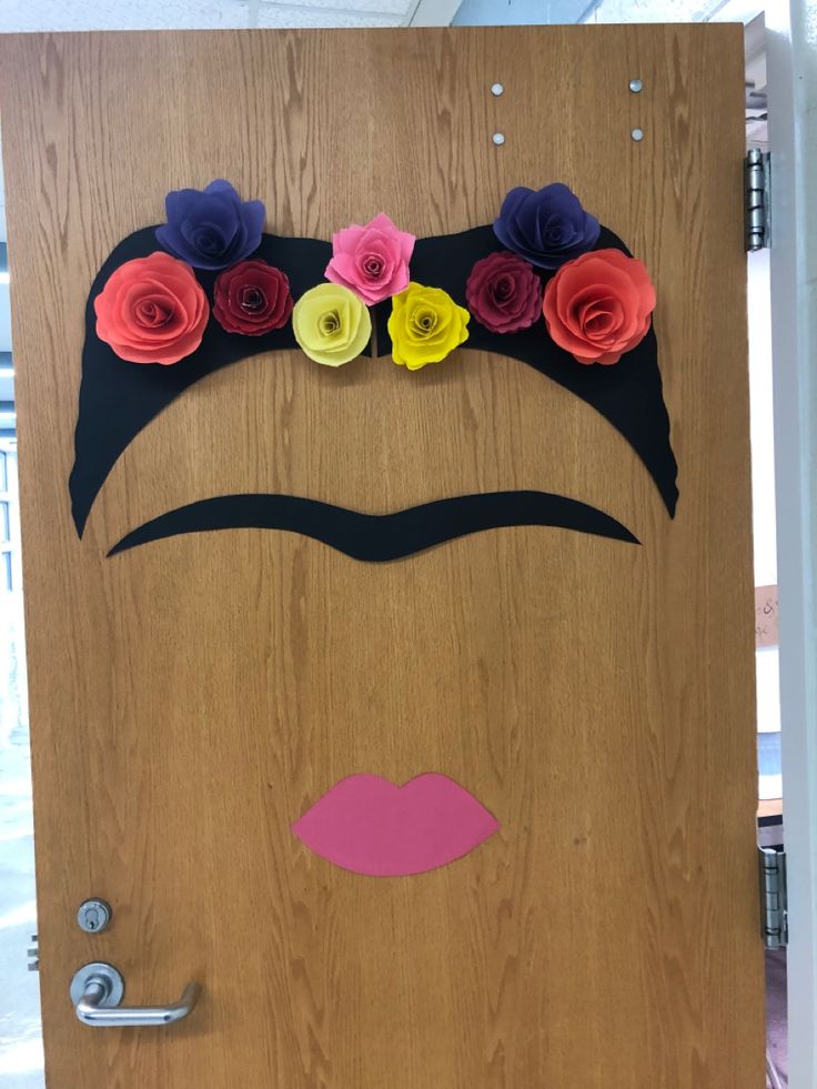 a door decorated with paper flowers and a man's face