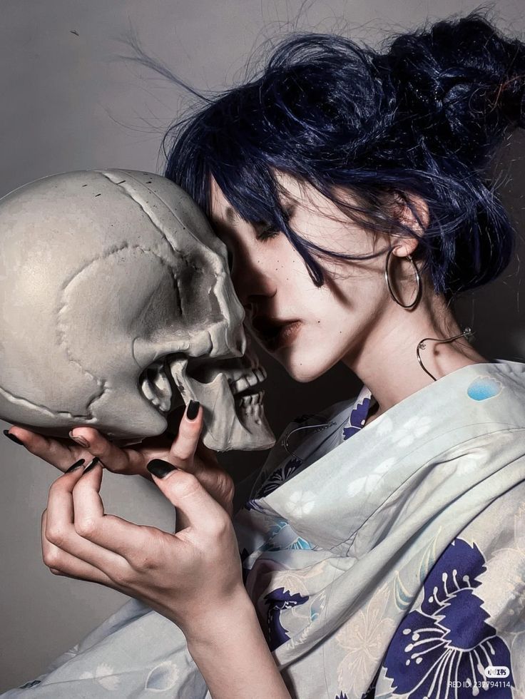 a woman holding a human skull in her hands