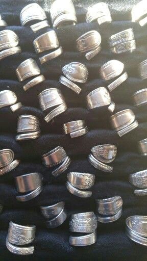 many silver rings sitting on top of black cloth