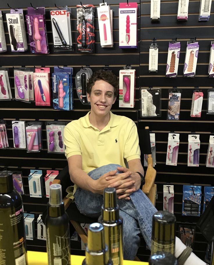 a man sitting in front of bottles of wine