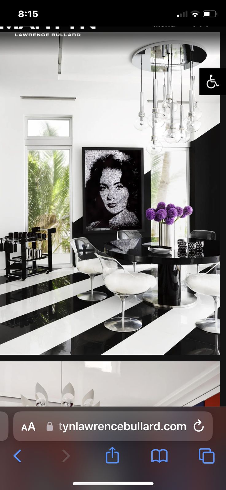 a black and white living room with chandelier, table, chairs and pictures on the wall