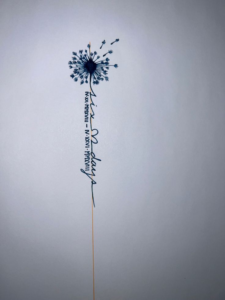 a dandelion with writing on it in the middle of a gray sky background