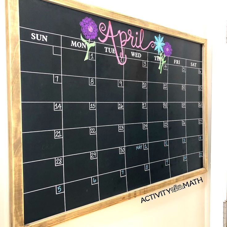 a blackboard with flowers on it and the word april written in pink chalk next to a clock