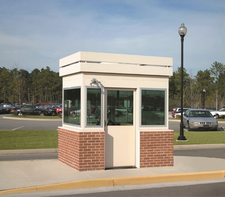 an empty bus stop sitting on the side of a road next to a parking lot