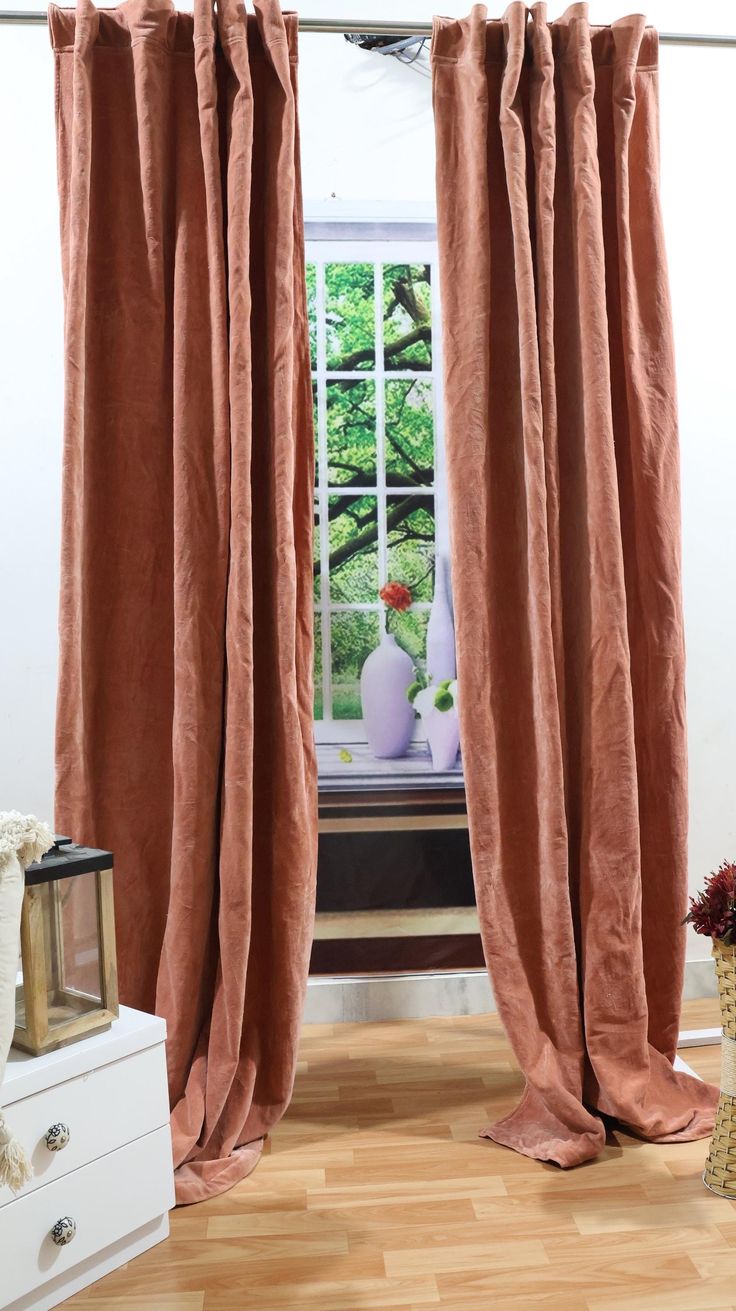 an open window with pink curtains and vases on the windowsill in front of it