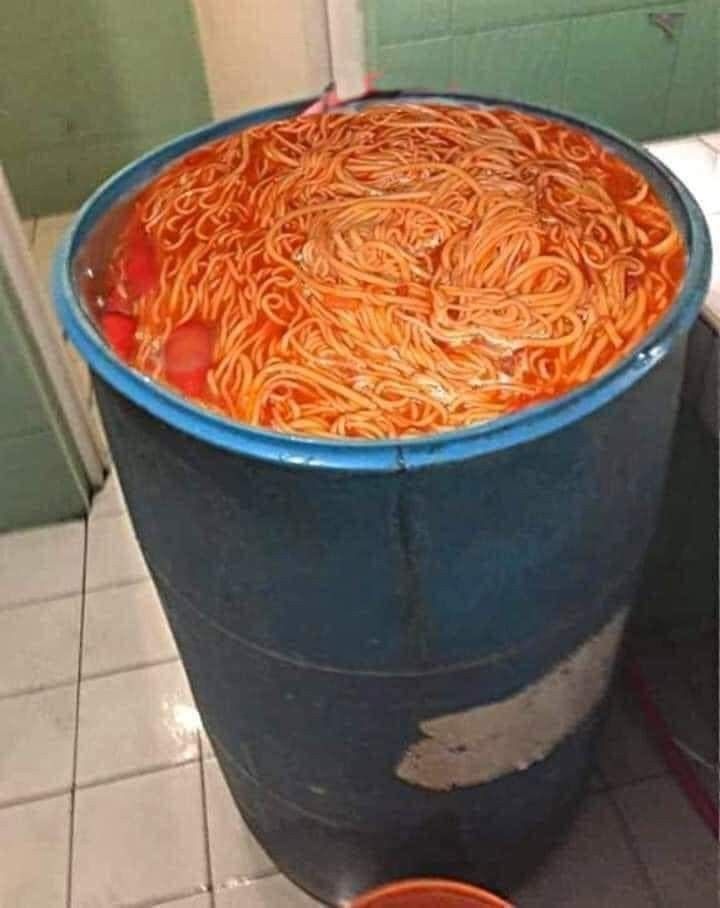 a bucket filled with noodles sitting on top of a tiled floor