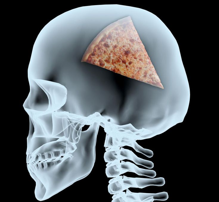 a piece of pizza in the middle of a skeleton's head with bones visible