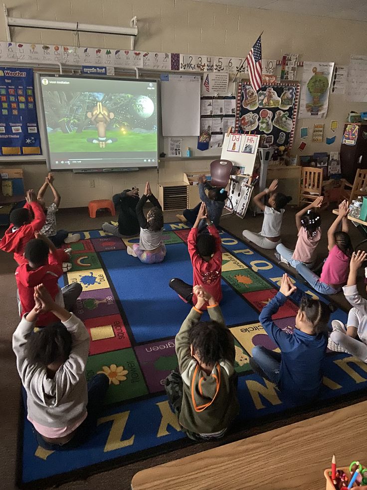 a group of children sitting on the floor in front of a tv