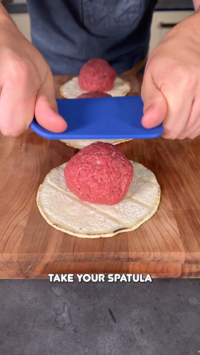 a person cutting up some food on top of a wooden board