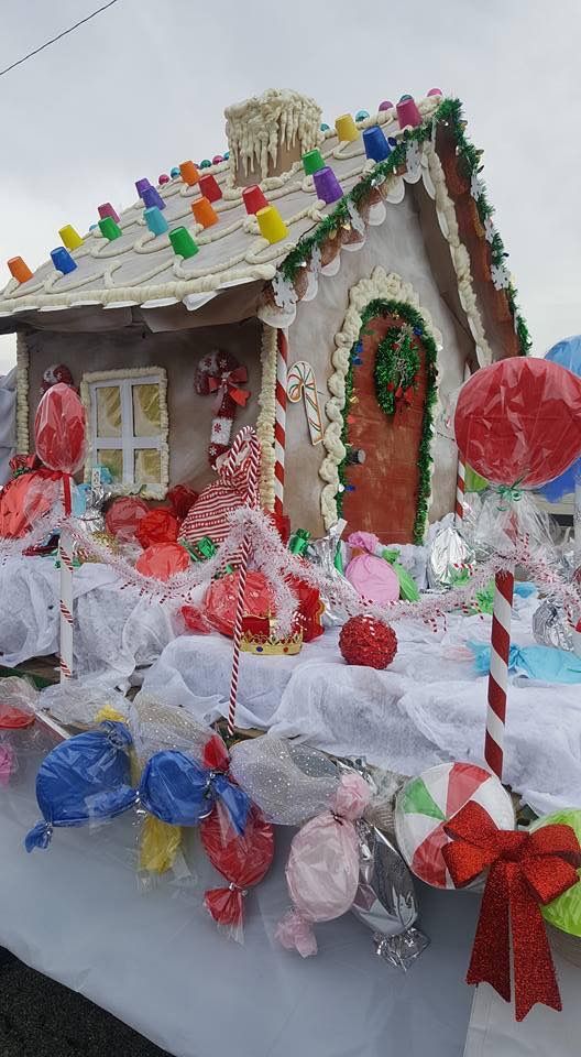 a gingerbread house decorated with candy canes and lollipops on a table