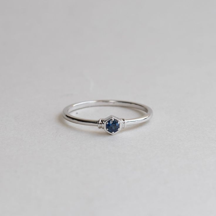 a white gold ring with a blue sapphire stone