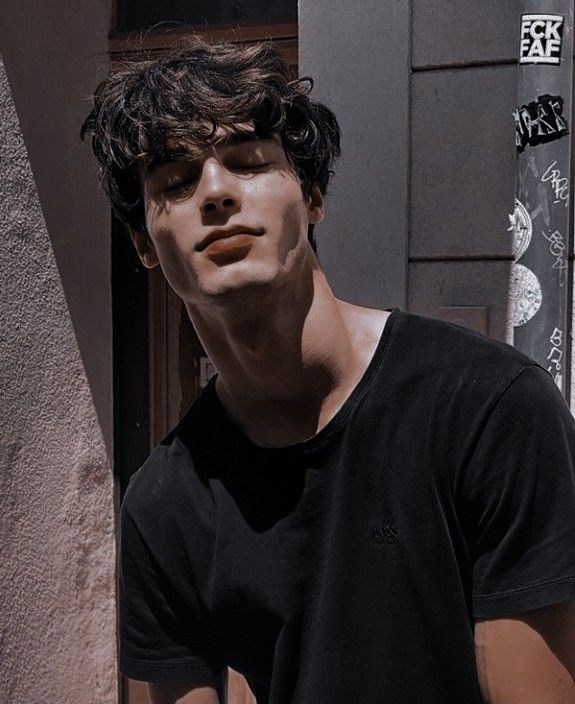 a young man standing in front of a building