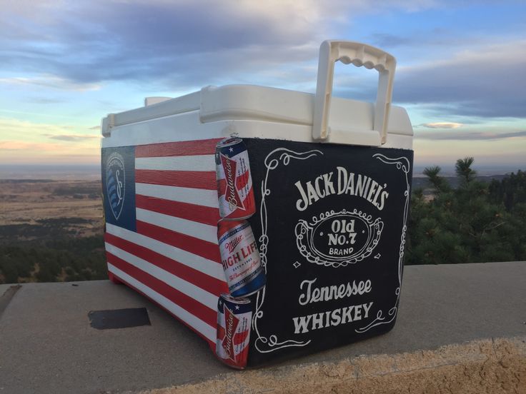 an american flag cooler box sitting on top of a hill overlooking the valley and trees