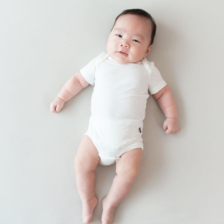 For the ultimate clothing staple for your little one’s closet, look no further than an infant bodysuit from Kyte Baby. Onesies are designed to be perfectly safe for sleep and follow all guidelines from the American Academy of Pediatrics. This convenient baby bodysuit features easy-to-use snaps for quick diaper changes and fold-over shoulders for fuss-free dressing. Crafted with buttery soft rayon made from bamboo, our short sleeve onesies offer a gentle touch, which is ideal for babies with ecze Nursery Aesthetic, Kyte Baby, Newborn Bodysuit, Baby Stage, Baby Layette, Gentle Touch, Versatile Outfits, All The Way Up, Short Sleeve Bodysuit