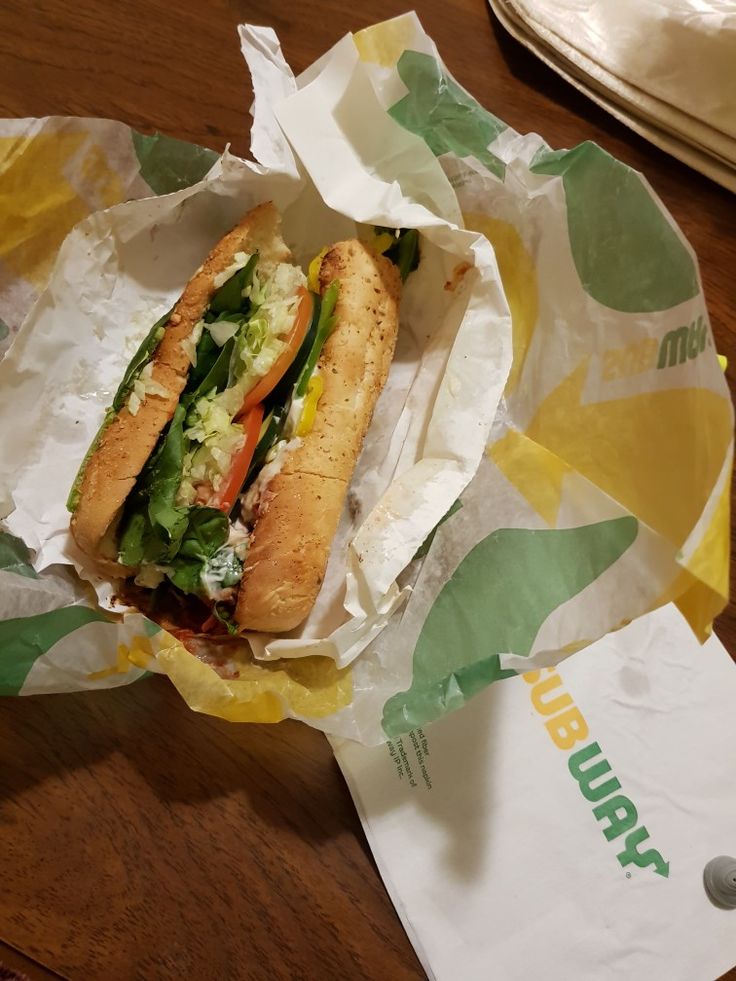 a sub sandwich sitting on top of a paper wrapper