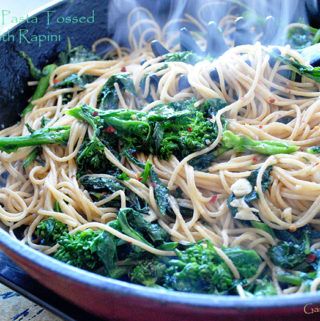 broccoli and noodles are being cooked in a pan