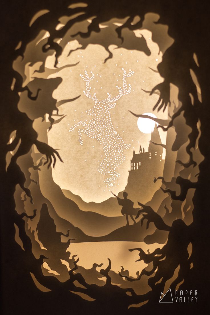 a paper cut out of the shape of a castle with bats flying in front of it