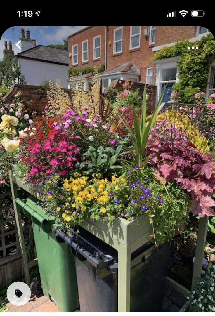 a green trash can filled with lots of flowers