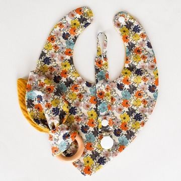 a baby bib and pacifier set made out of fabric with flowers on it