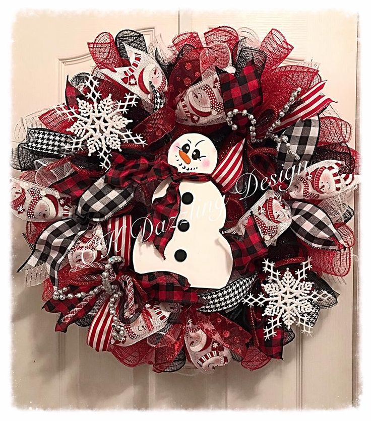 a red and black wreath with a snowman on it