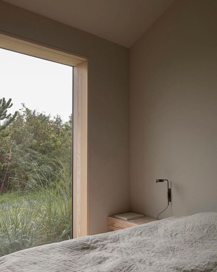 a bed sitting next to a window in a bedroom