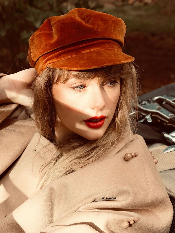 a woman wearing a brown hat and trench coat