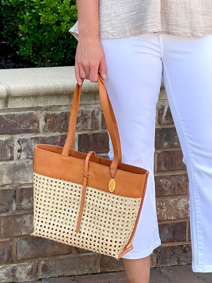 Made from harvested rattan and tan grain leather, this trendy boho cane weave tote bag features a convenient snap closure with a stylish strap. The cognac color and trim with a zipper pocket makes this purse fashionable, multi-purpose and easy to use. Casual Light Brown Bucket Bag With Braided Handles, Casual Light Brown Hobo Bag With Leather Handles, Casual Cognac Shoulder Bag With Leather Handles, Spring Travel Hobo Bag With Leather Handles, Brown Woven Leather Straw Bag For Shopping, Casual Basket-shaped Woven Leather Bag, Light Brown Tote Bucket Bag With Braided Handles, Light Brown Bucket Bag With Braided Handles, Chic Brown Straw Bag With Double Handle