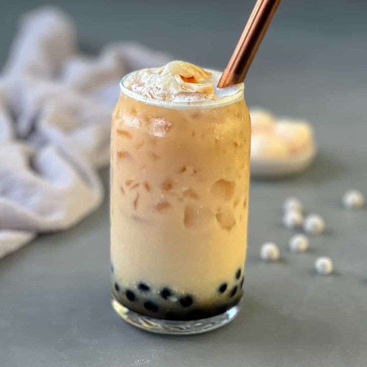 an iced drink in a glass with a straw on the top and black speckles around it