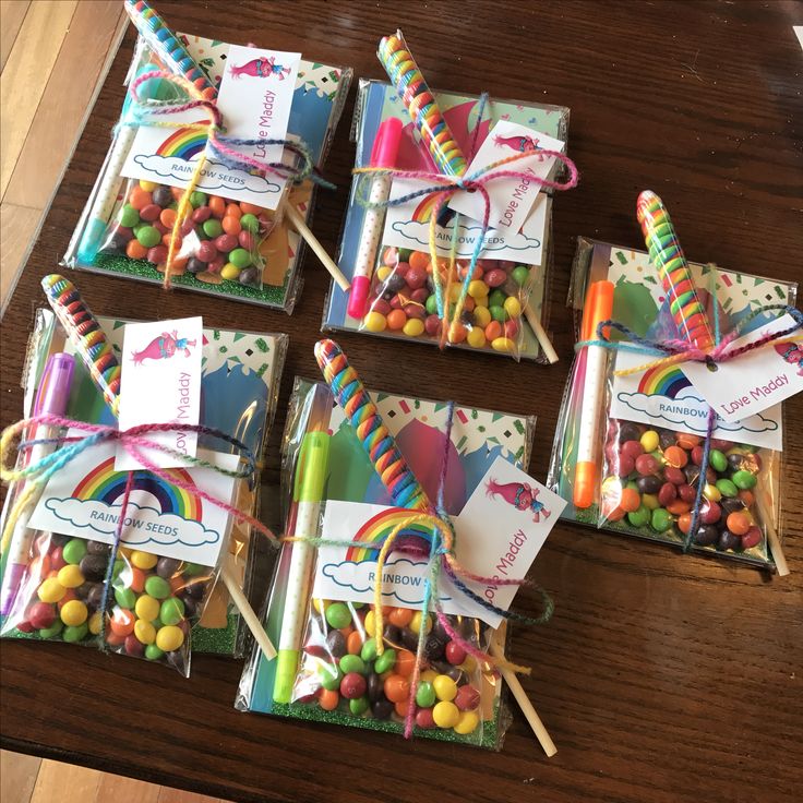 small candy bags with colorful candies and lollipops in them on a table