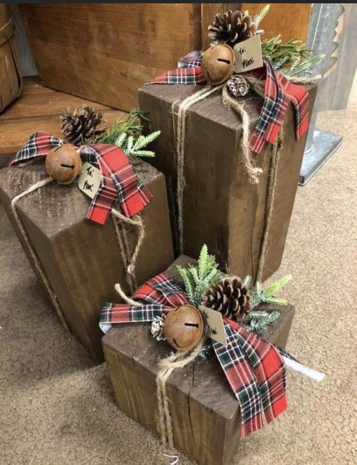 three wooden boxes decorated with pine cones and plaid ribbon are sitting on the floor next to each other