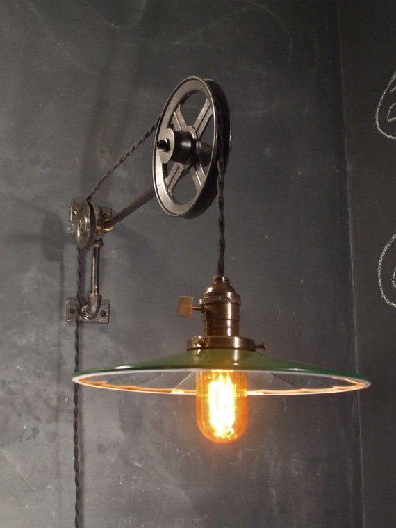 an industrial style light hanging from the side of a chalkboard wall with writing on it