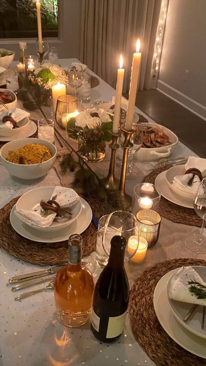 a dinner table with candles and dishes on it