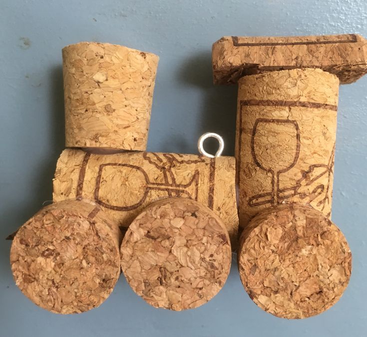 three wine corks are arranged in the shape of a train on a blue wall