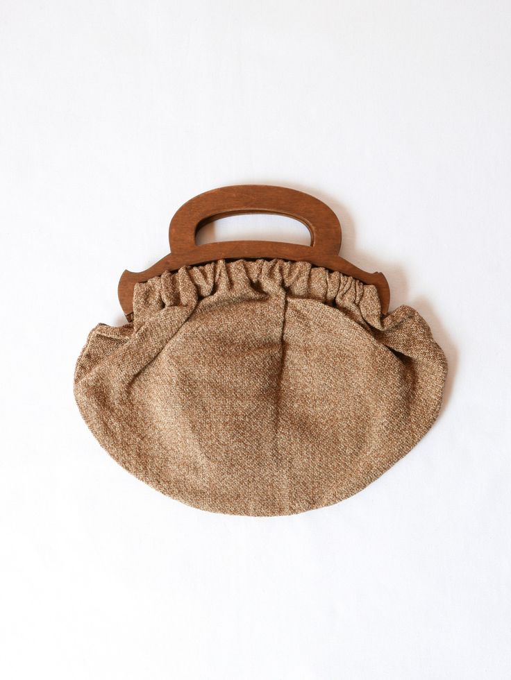 Petite wood handled purse. Perfect amount of room for your essentials. Hand-embroidered florals adorn the front. 12w x 8h inches With handle 12w x 10.5h inches Condition: Very good. Small chip in handle. Handheld Beige Bags With Rolled Handles, Brown Bags With Top Carry Round Handle, Handheld Beige Bag With Rolled Handles, Brown Bag With Top Carry And Round Handle, Beige Handheld Bag With Rolled Handles, Vintage Handheld Bag With Bamboo Handle, Brown Bags With Bamboo Handle, Brown Bags With Bamboo Handle For On-the-go, Brown Bag With Round Handle For On-the-go