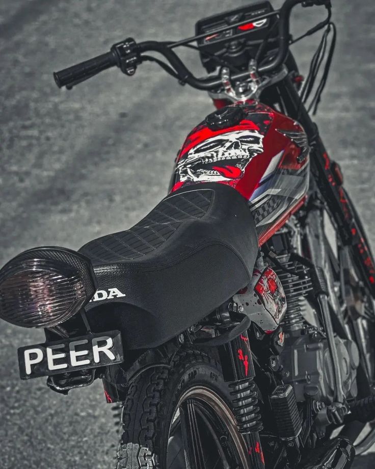 a red and black dirt bike parked on the street